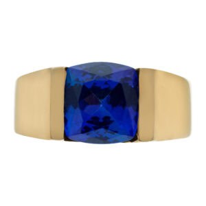 Chanel set cushion cut faceted blue/purple tanzanite in an 18k gold tension setting